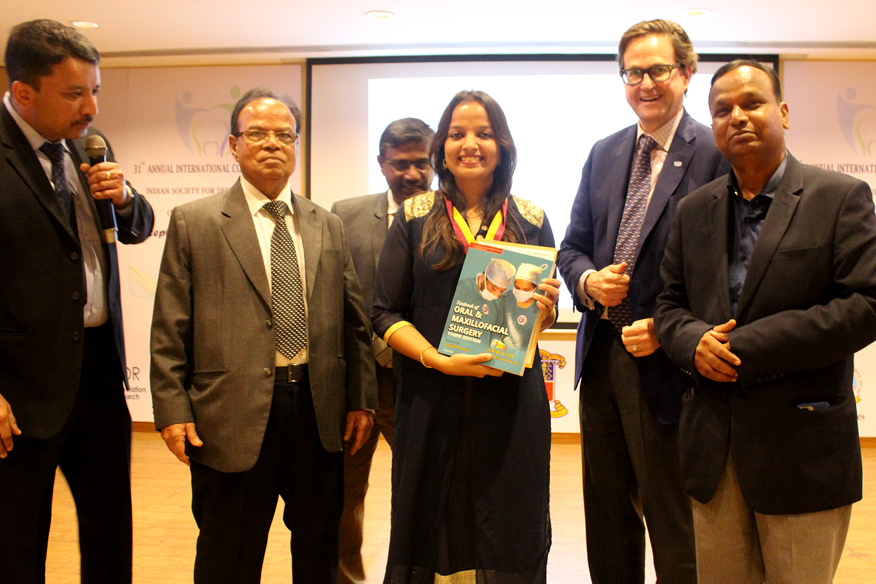 31st Indian Society for Dental Research - International Association for Dental Research Annual Conference, Mumbai 17 A Top Ranker Being Presented With Dr Sm Balaji’s Textbook Of Oral And Maxillofacial Surgery